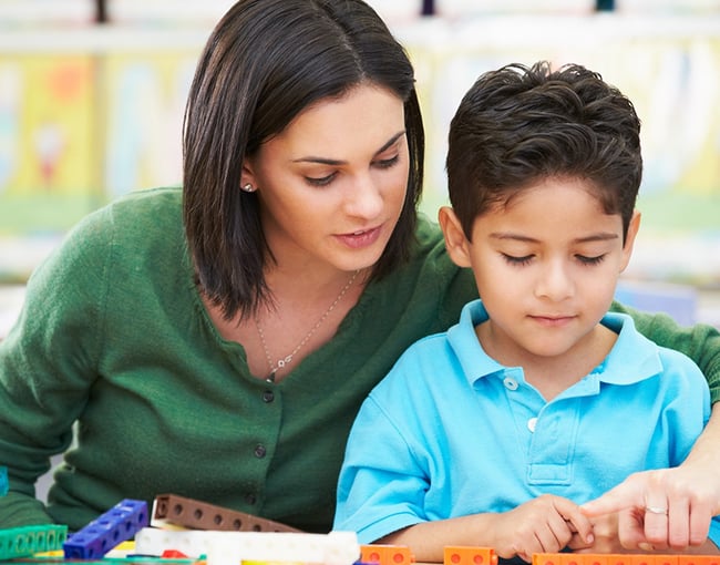 Latino Student with Teacher and Counting Cubes